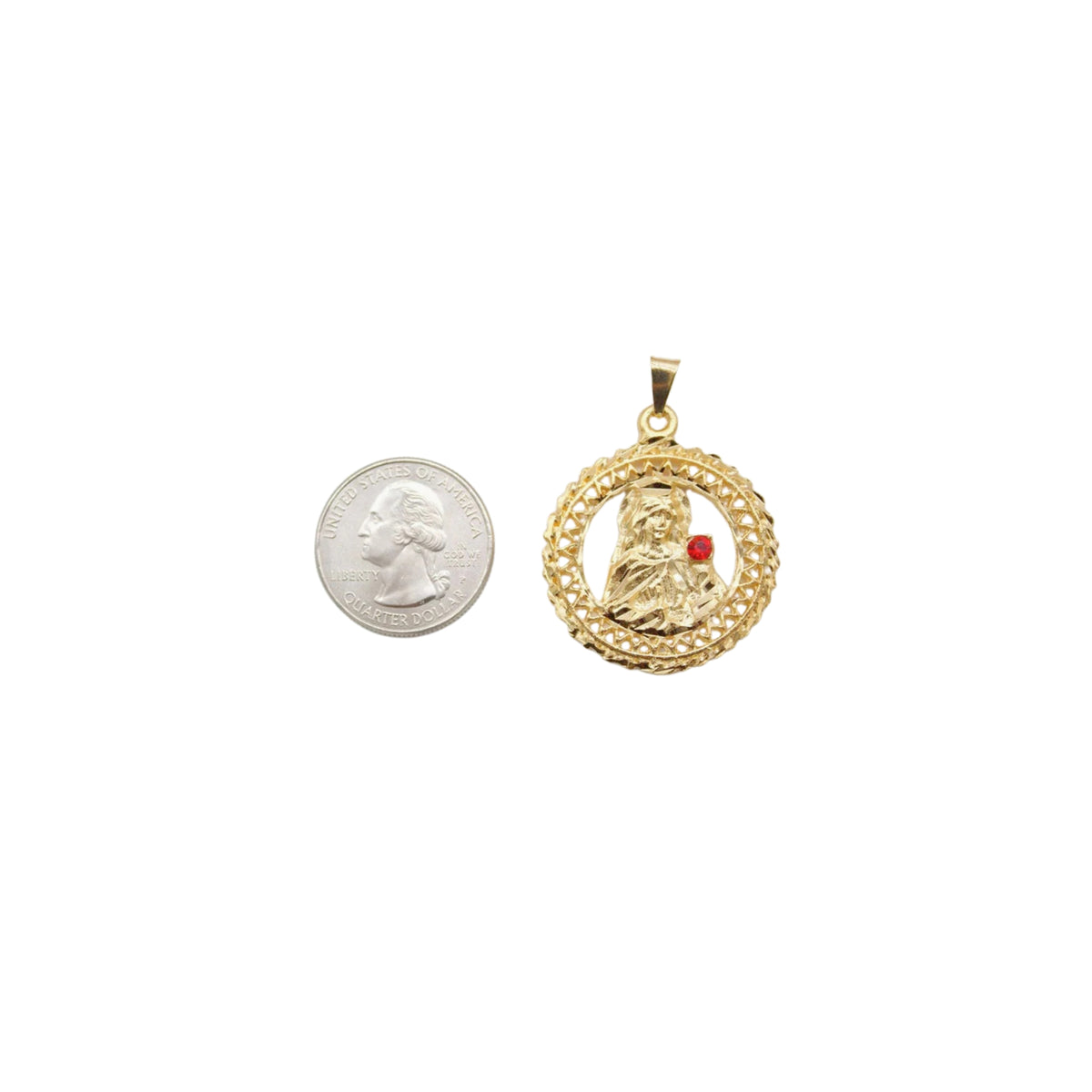 A round gold pendant featuring a depiction of the Virgin Mary with a red gemstone rests next to a US quarter coin for size comparison.