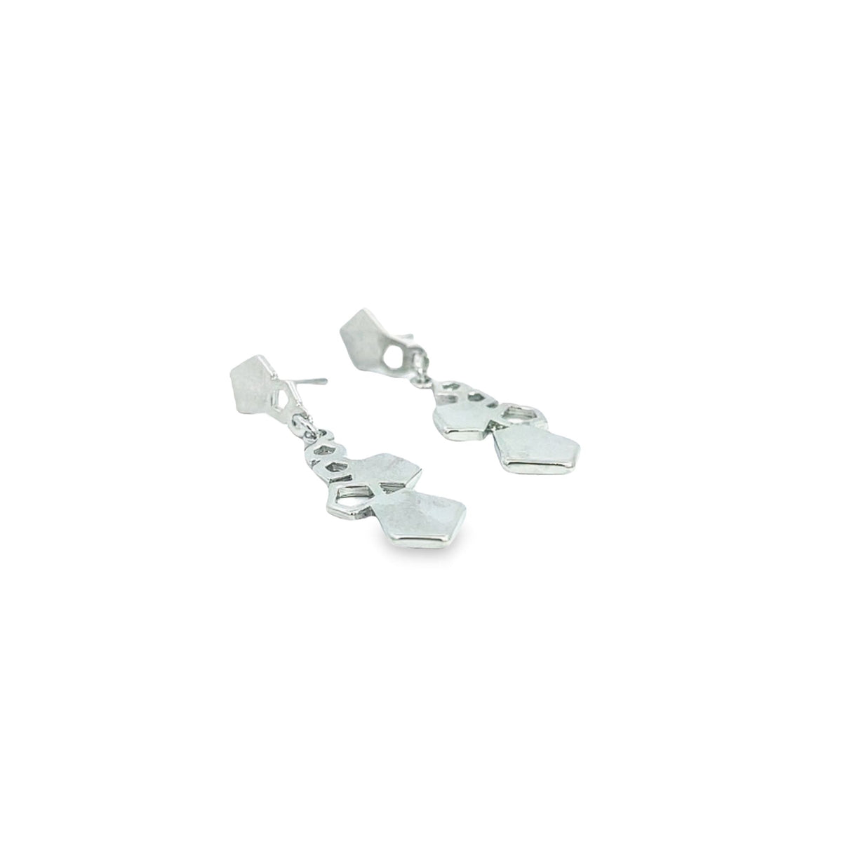 A pair of modern silver geometric dangle earrings rests on a clean white surface.