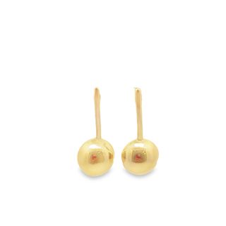 A pair of polished gold ball drop earrings gleams against a clean white background.