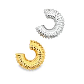 A shiny gold and silver pair of ribbed croissant hoop earrings rest against a clean white background.