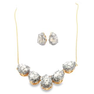 A matching jewelry set features a gold chain necklace and teardrop earrings adorned with white and gray mottled stones.