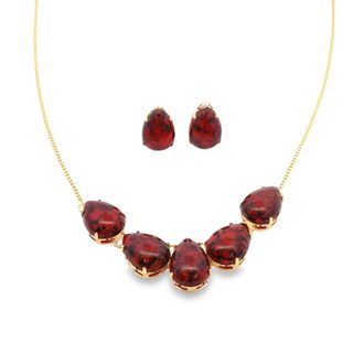 A gold jewelry set features a delicate chain necklace adorned with five pear-shaped dark red gemstones and matching teardrop earrings.