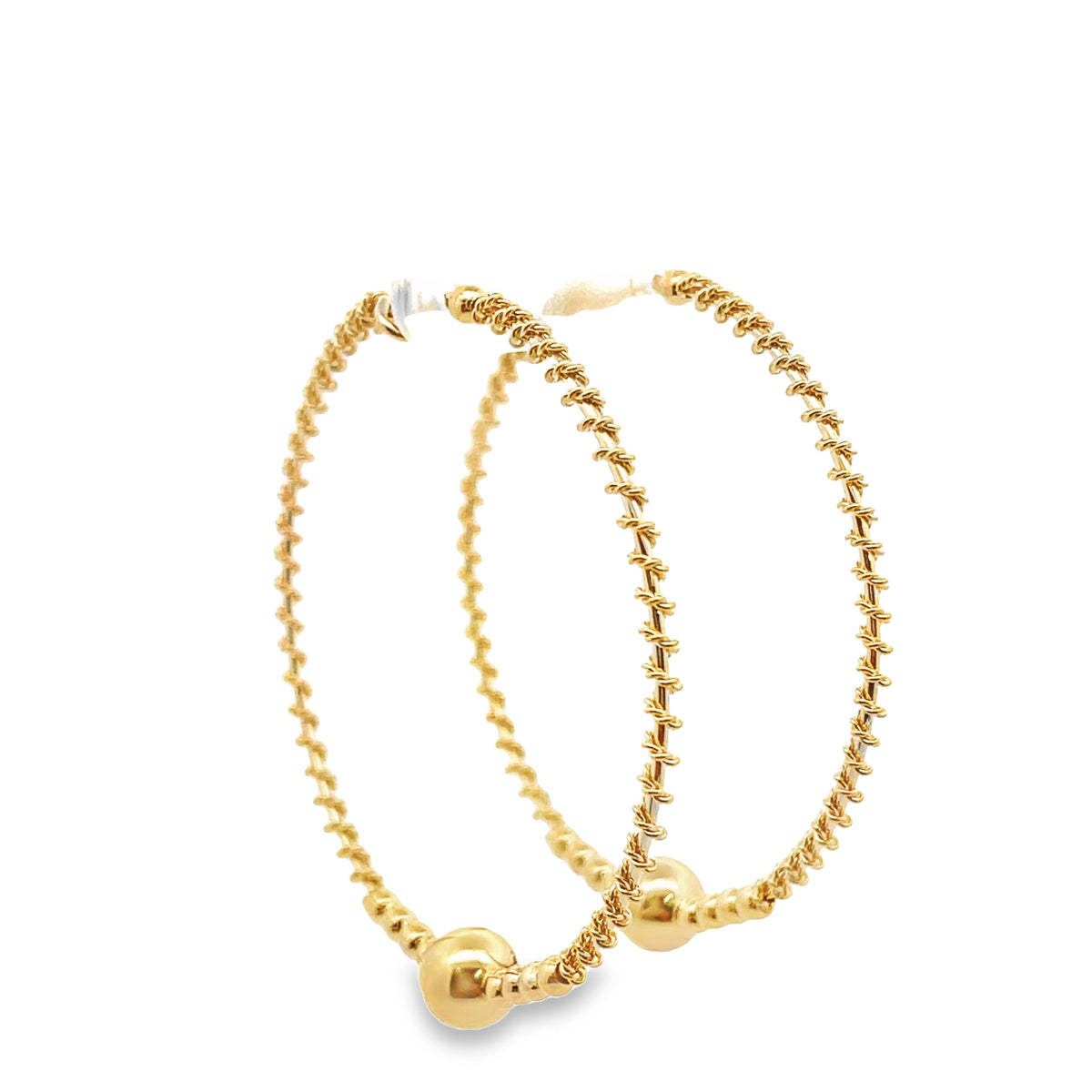A pair of textured gold hoop earrings featuring a braided design and a smooth ball detail at the bottom against a white background.