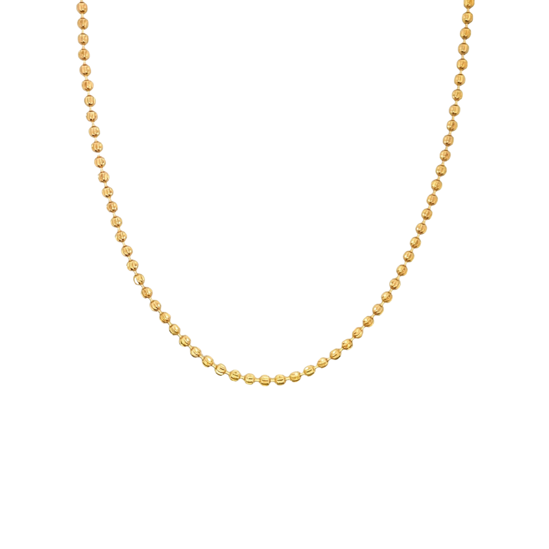 A delicate gold bead chain necklace drapes in a graceful curve against a clean white background.