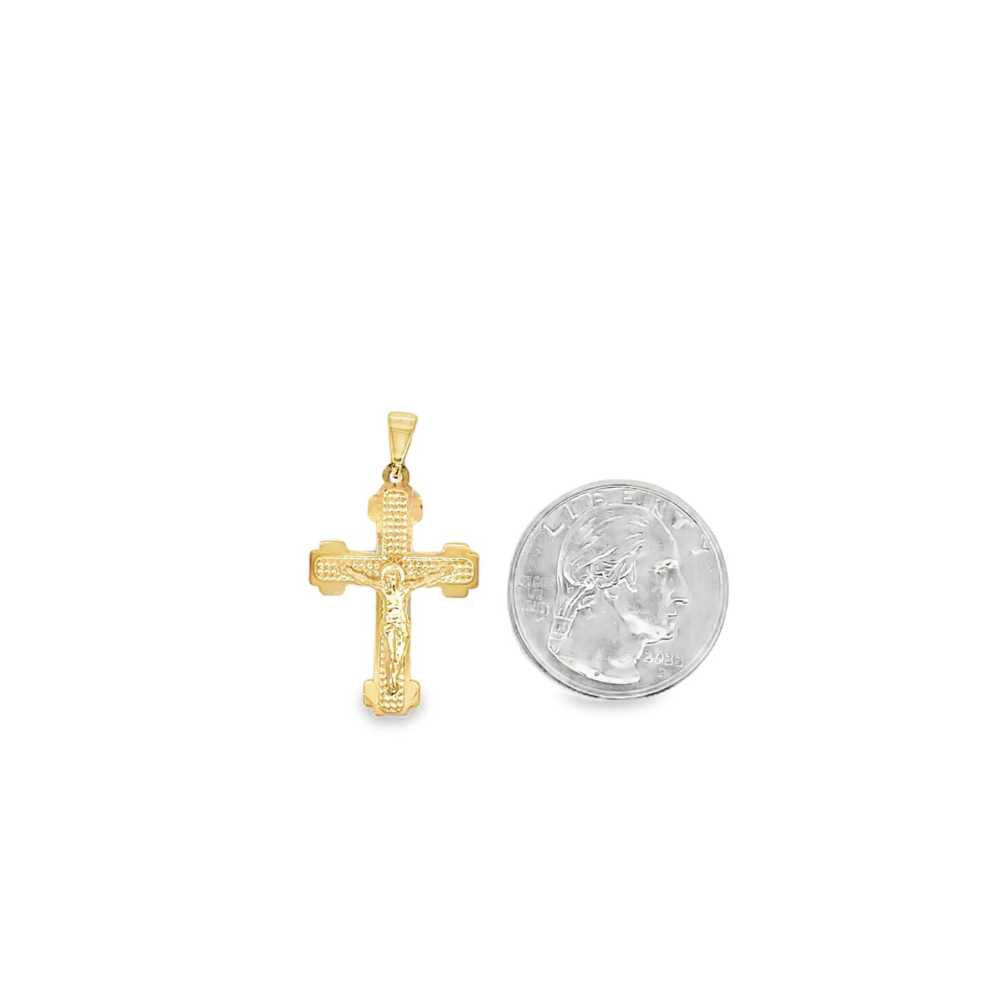 A gold crucifix pendant rests next to a US quarter coin to show scale.