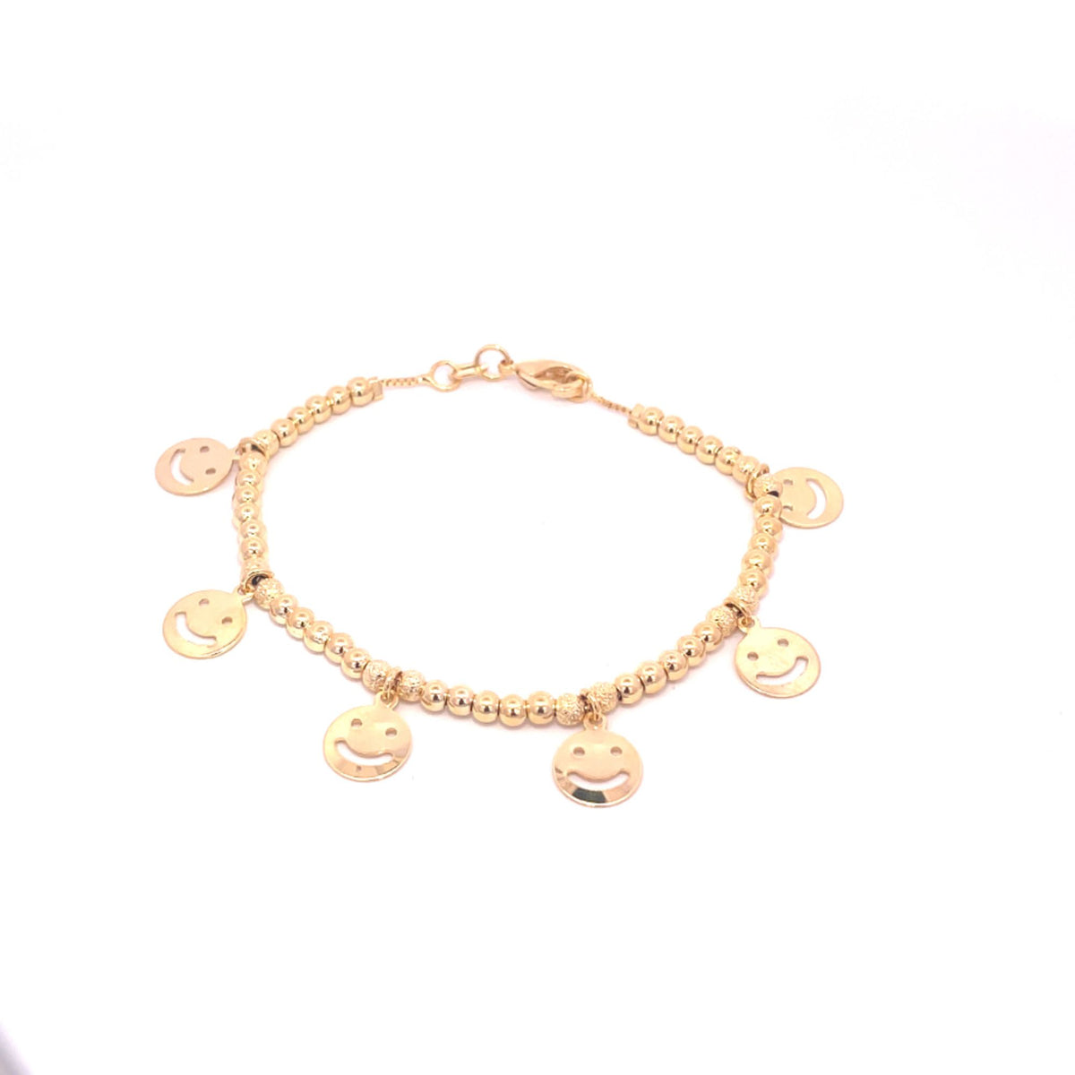 A delicate gold beaded bracelet features dangling smiley face charms against a white background.