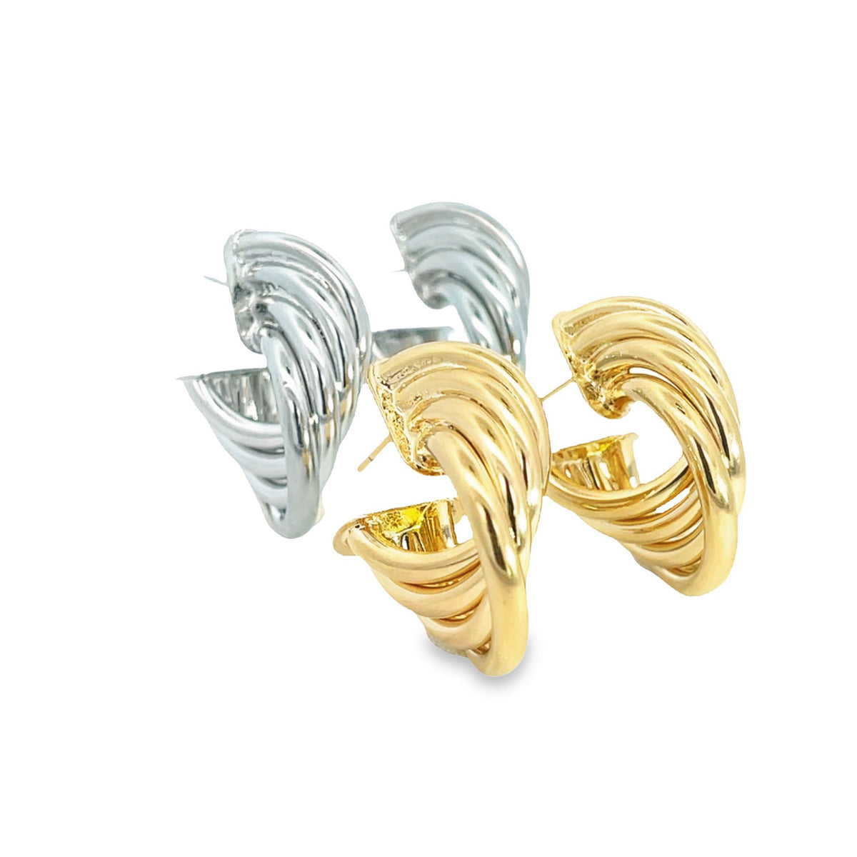A pair of gold and silver textured hoop earrings rest on a clean white background.