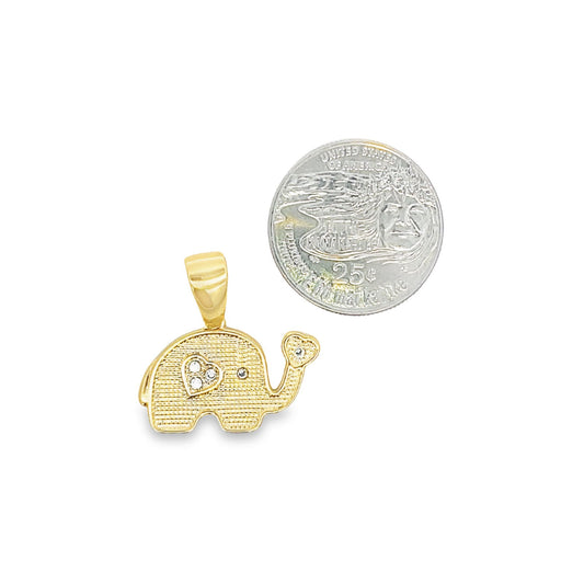 A textured gold elephant pendant with a diamond-accented heart sits next to a quarter for size comparison.