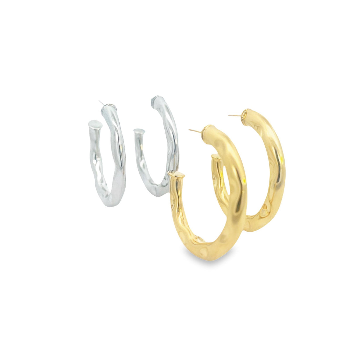 Two pairs of chunky, textured metal hoop earrings in silver and gold rest on a white background.