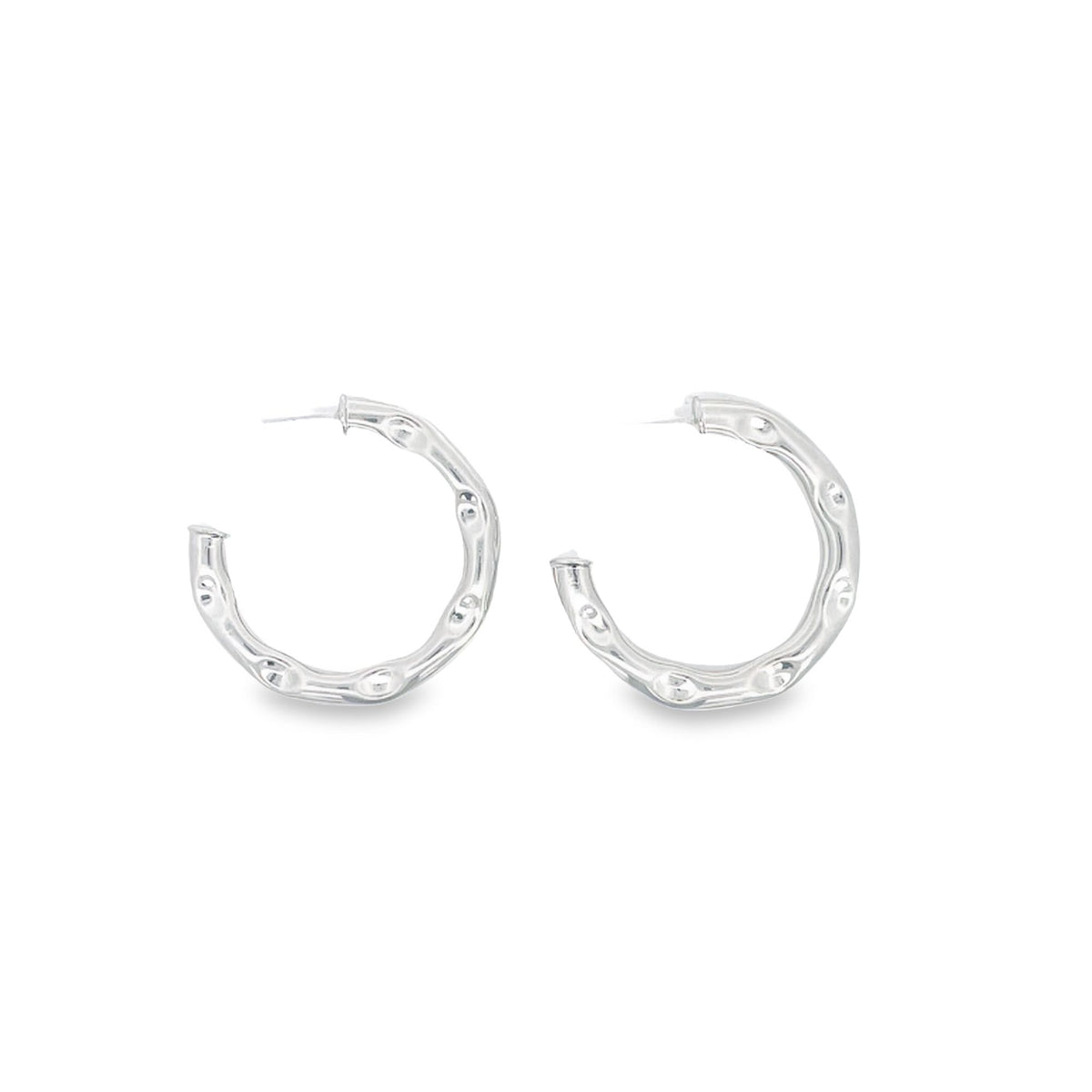 A pair of textured silver hoop earrings rests against a clean white background.