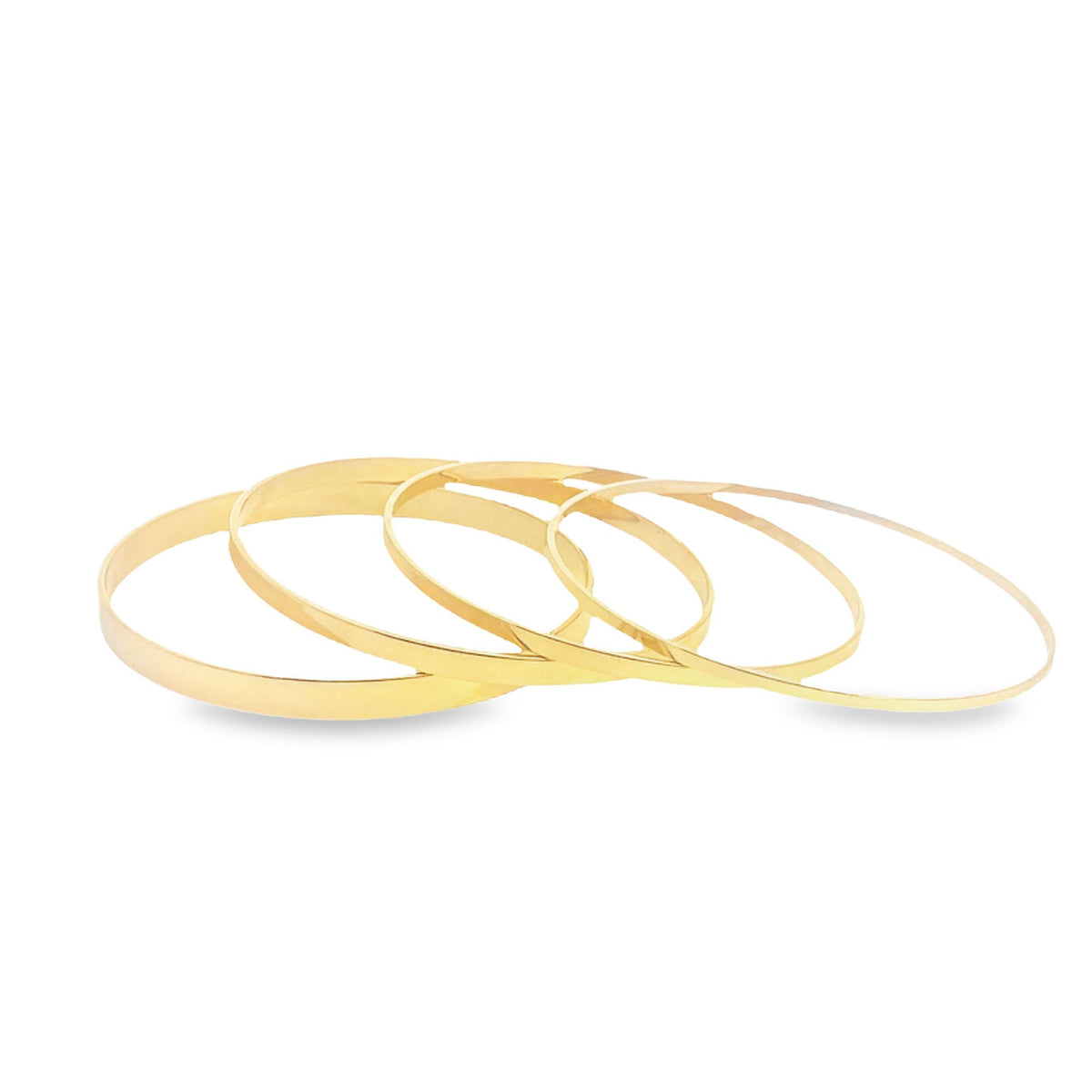 A stack of sleek gold bangles rests neatly on a clean white surface.