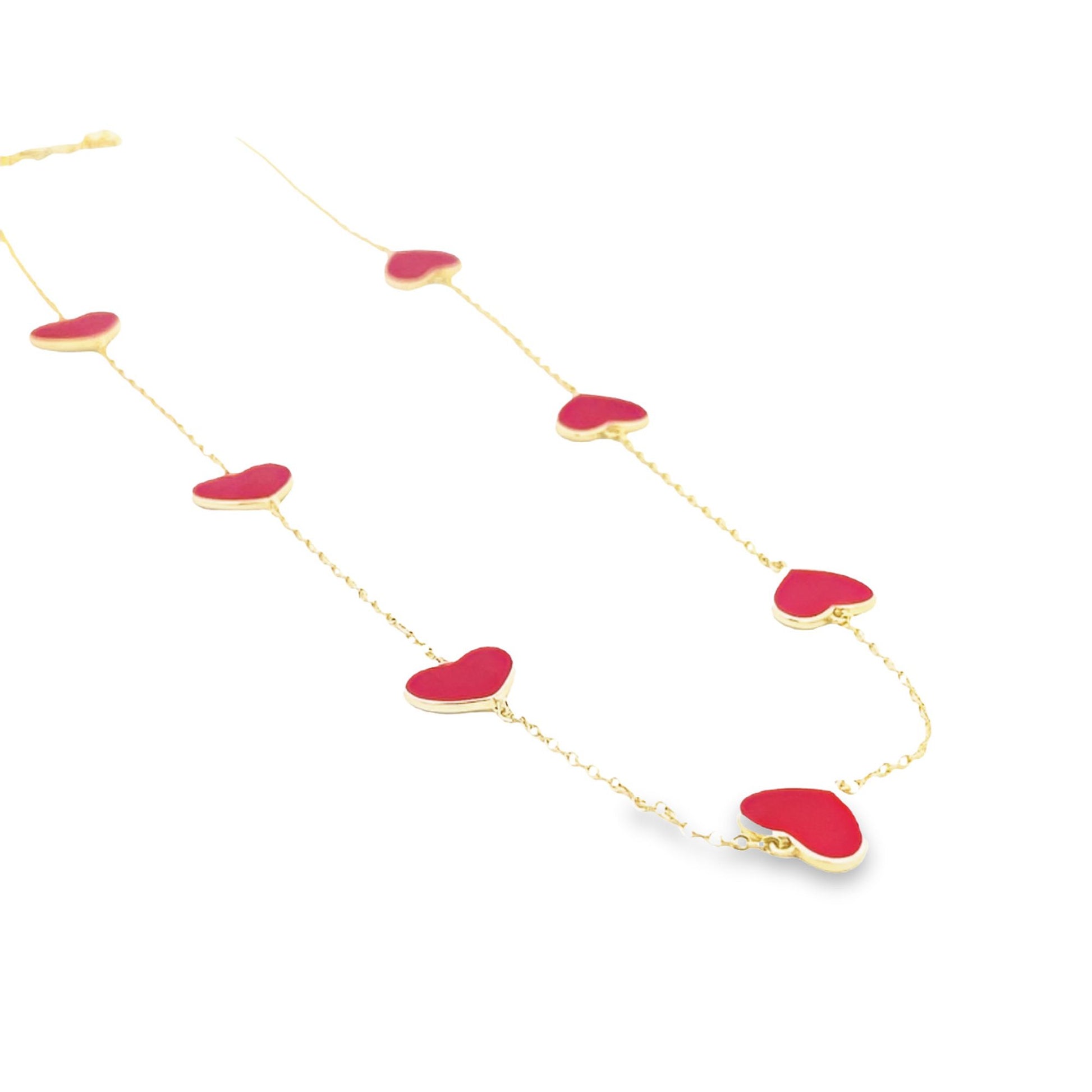 A delicate gold chain necklace features scattered red enameled heart charms against a clean white background.