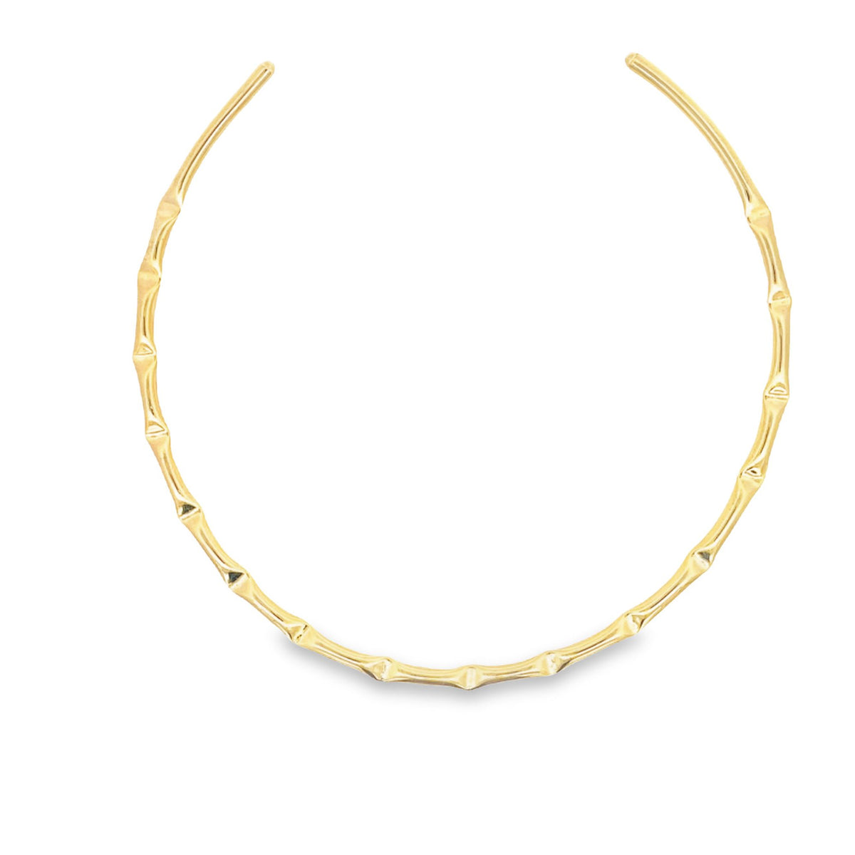 A polished gold bamboo-style choker necklace sits against a plain white background.