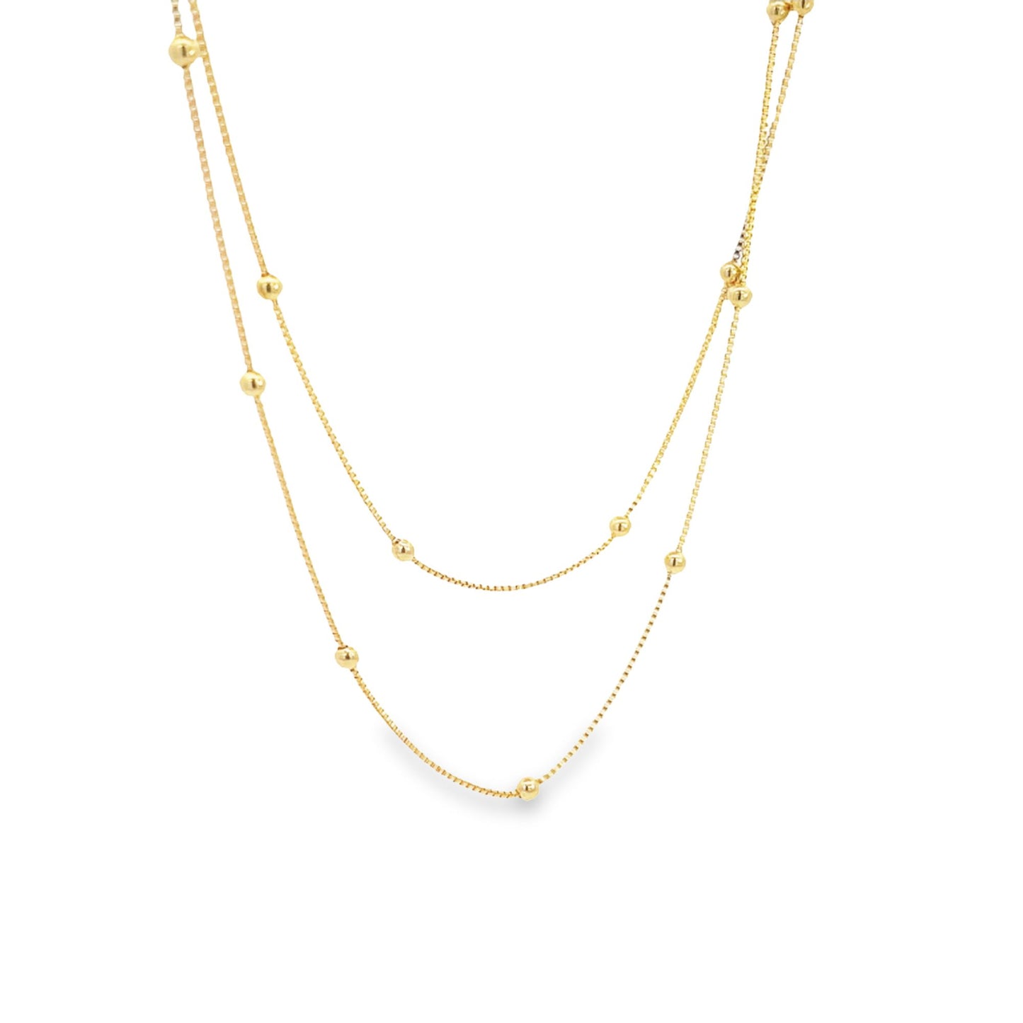 A delicate double-layered gold chain necklace features evenly spaced spherical beads along its thin links against a plain white background.