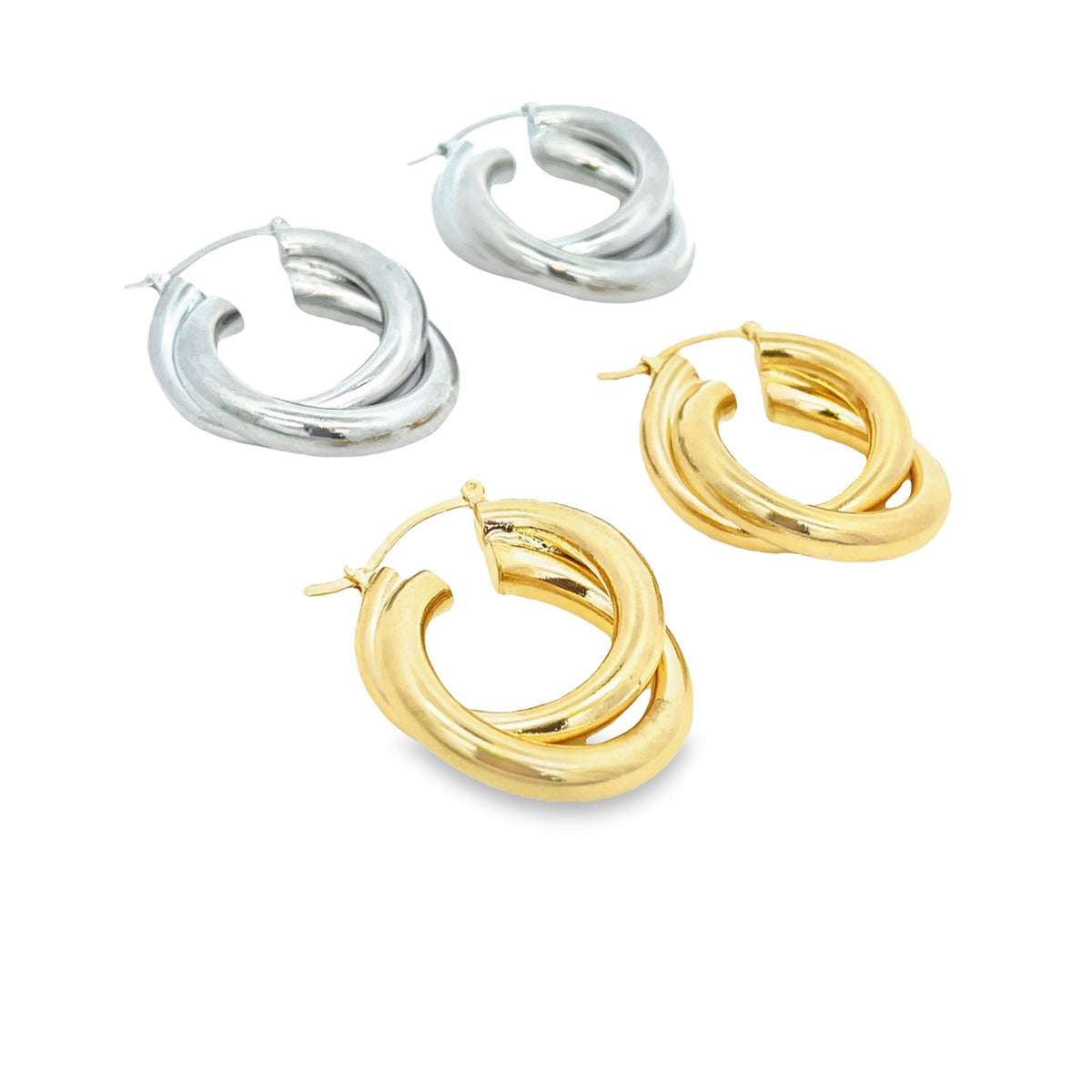 Two pairs of chunky, interlocking double hoop earrings rest against a white background, featuring polished silver and gold finishes.