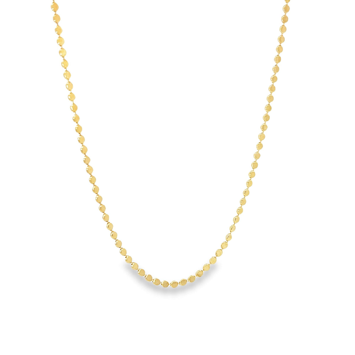 A delicate gold beaded necklace drapes gracefully against a plain white background.