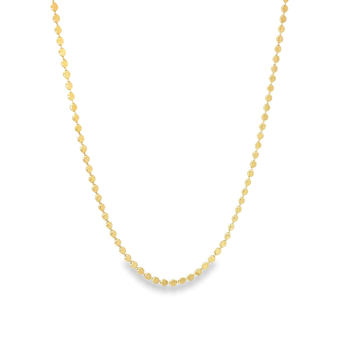 A delicate gold chain necklace with evenly spaced flat disc beads hangs in a graceful curve against a plain white background.