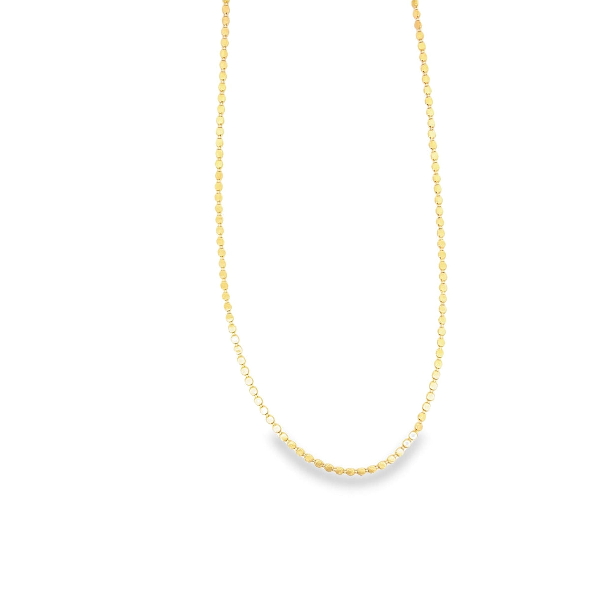 A delicate gold chain necklace with small, shimmering disc links rests against a clean white background.
