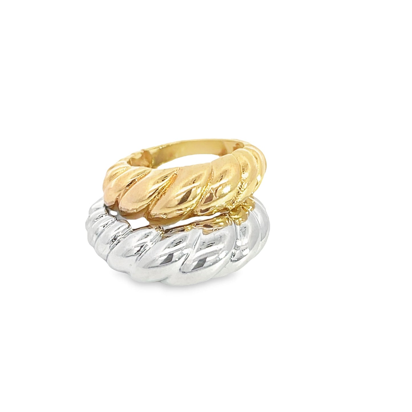 A stacked pair of shiny gold and silver croissant-style dome rings rests against a plain white background.