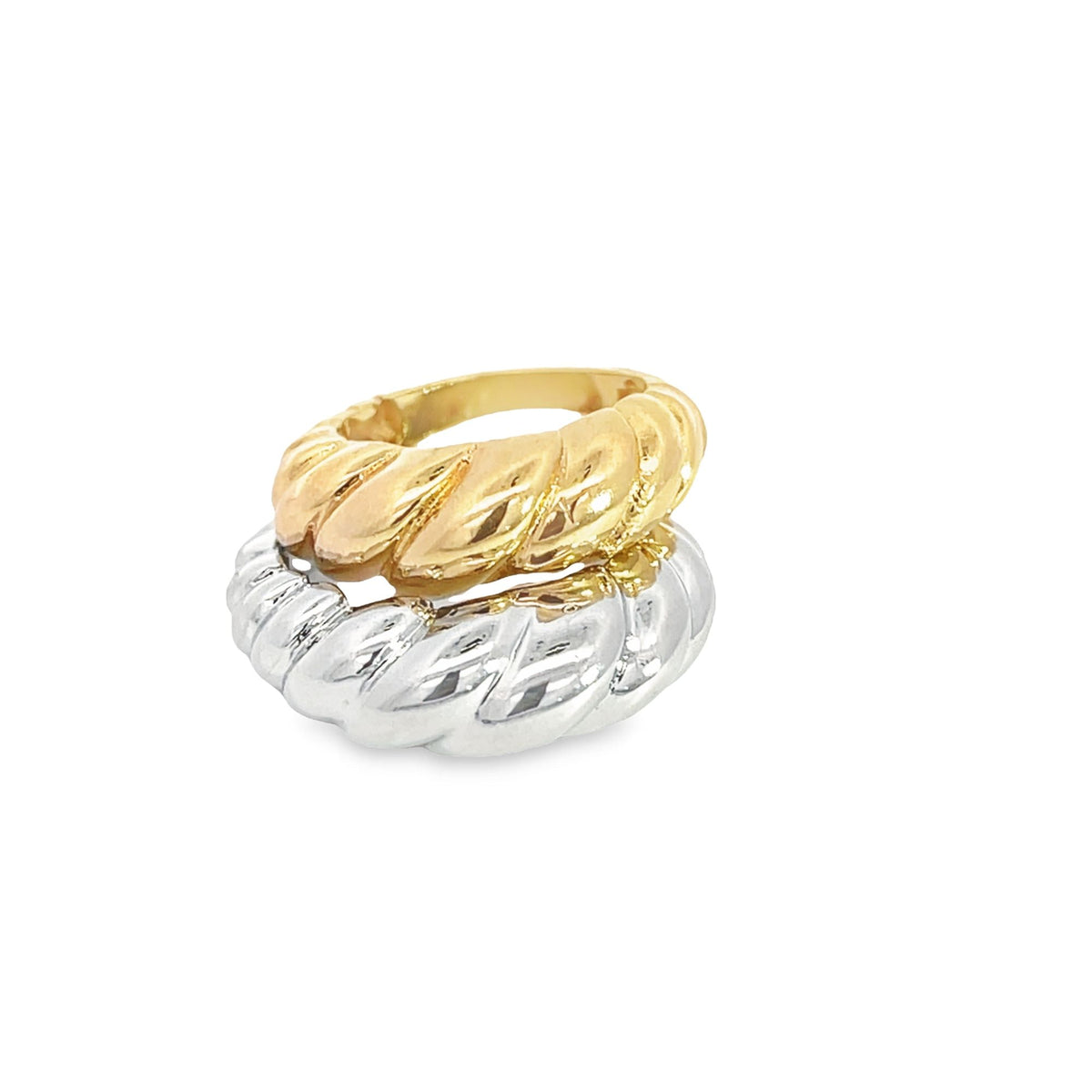 A stacked pair of shiny gold and silver croissant-style dome rings rests against a plain white background.