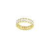 A gold eternity ring features a continuous band of sparkling emerald-cut baguette stones set against a clean white background.
