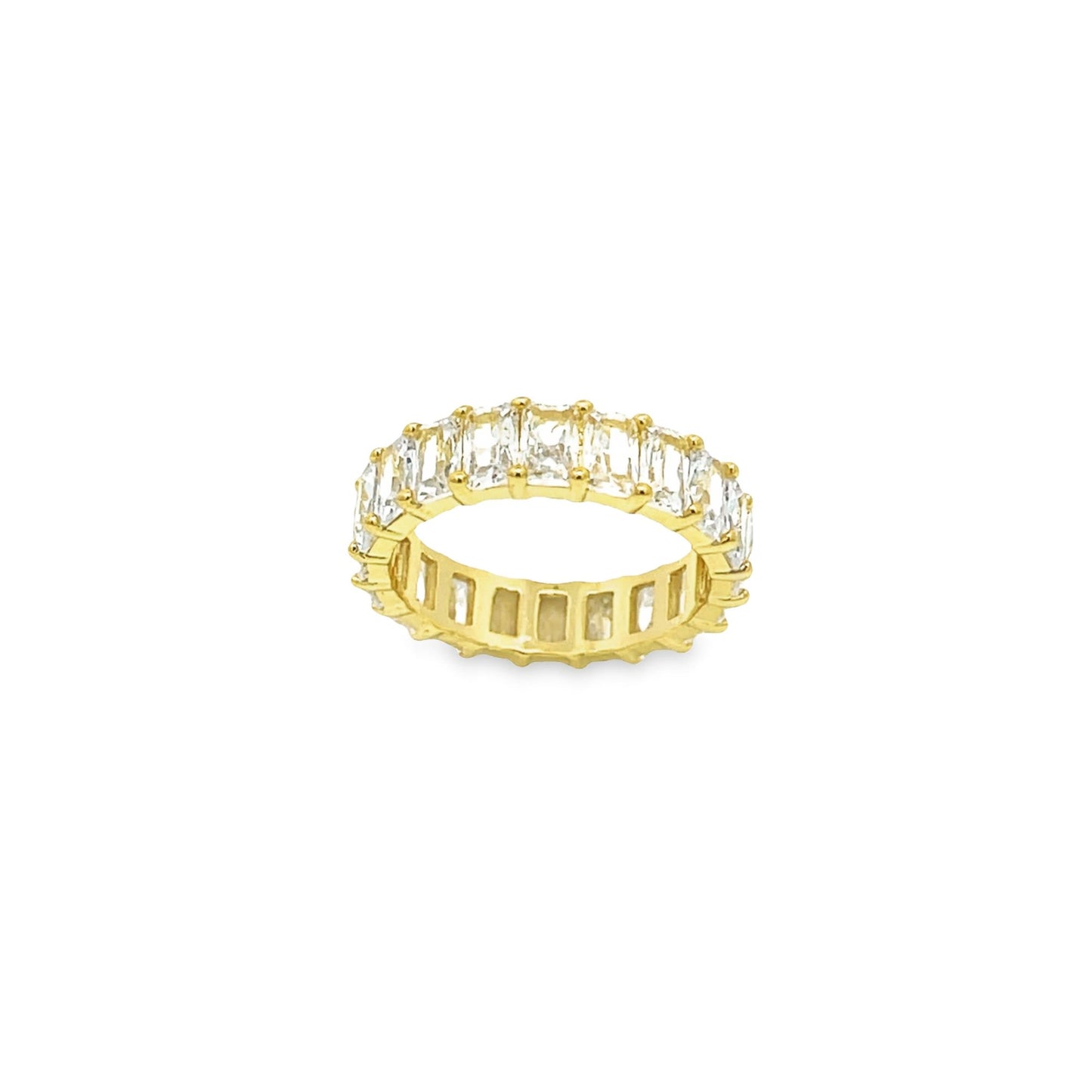A gold eternity ring features a continuous band of sparkling emerald-cut baguette stones set against a clean white background.