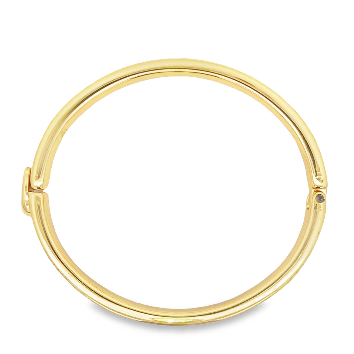 A polished yellow gold hinged bangle bracelet rests against a clean white background.