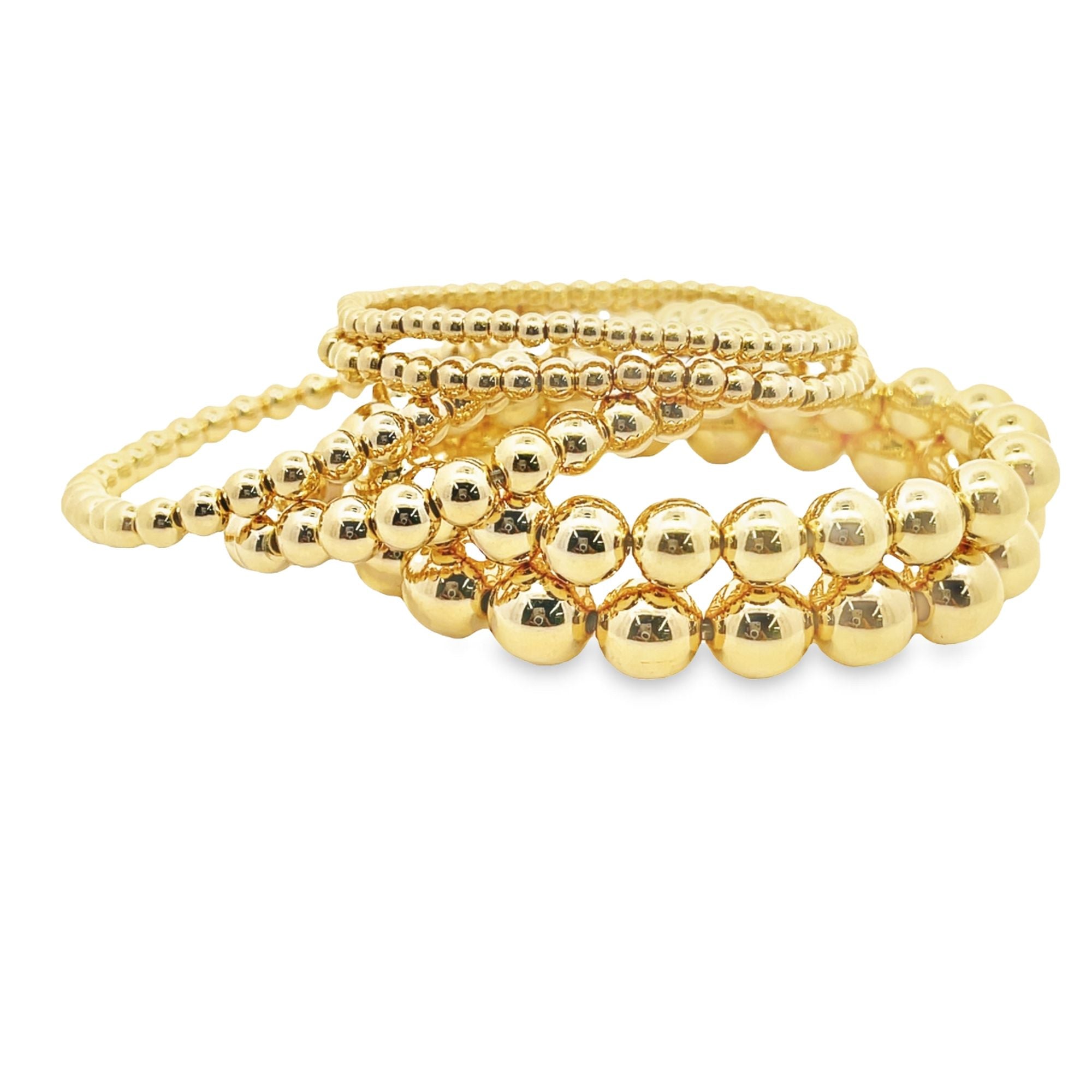 A stylish stack of shiny gold beaded bracelets rests on a clean white background.