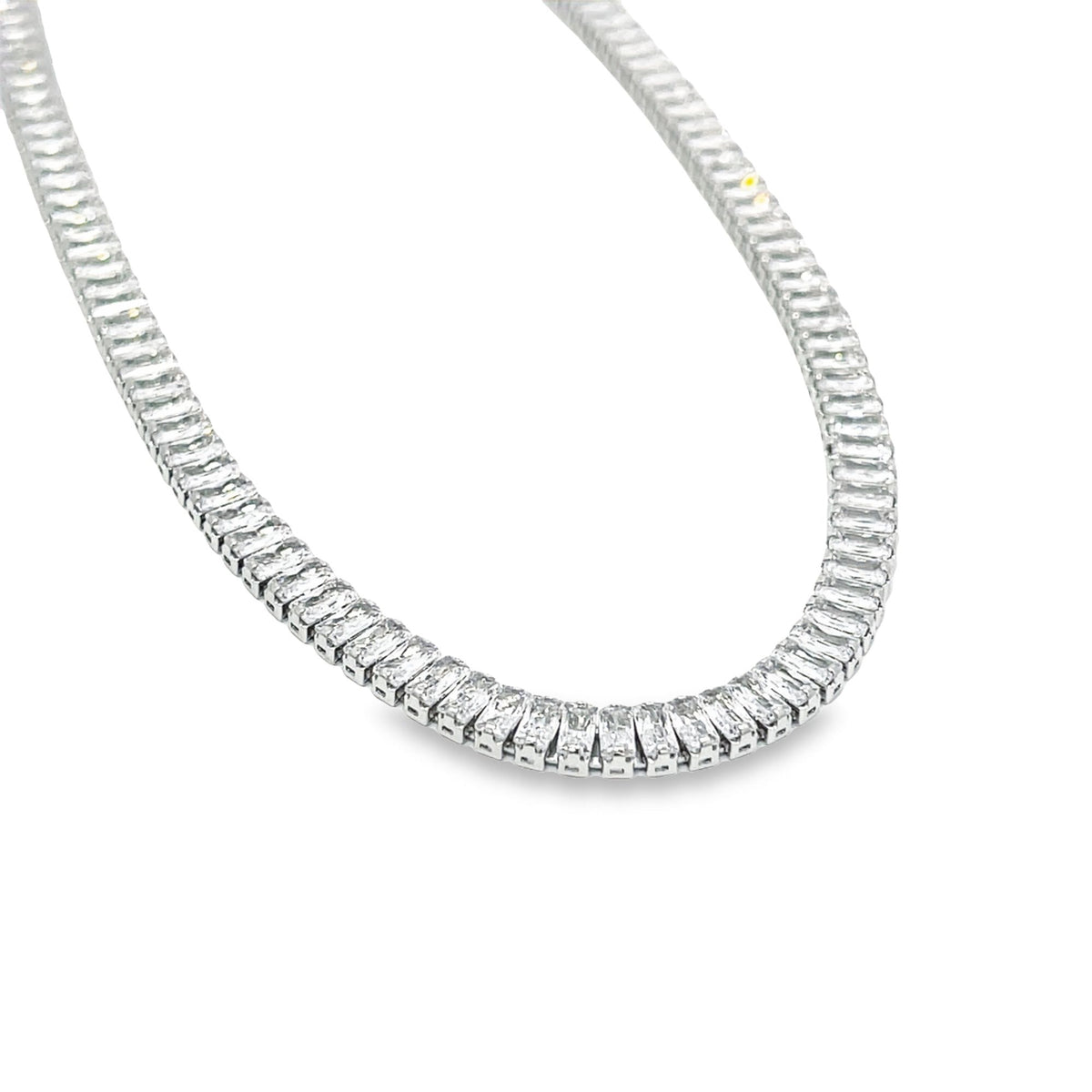 A sparkling diamond tennis necklace made of baguette-cut stones rests gracefully against a clean white background.