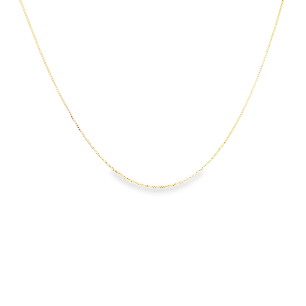A delicate yellow gold box chain necklace drapes against a white background.