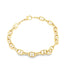 A polished gold anchor chain bracelet rests on a plain white surface.