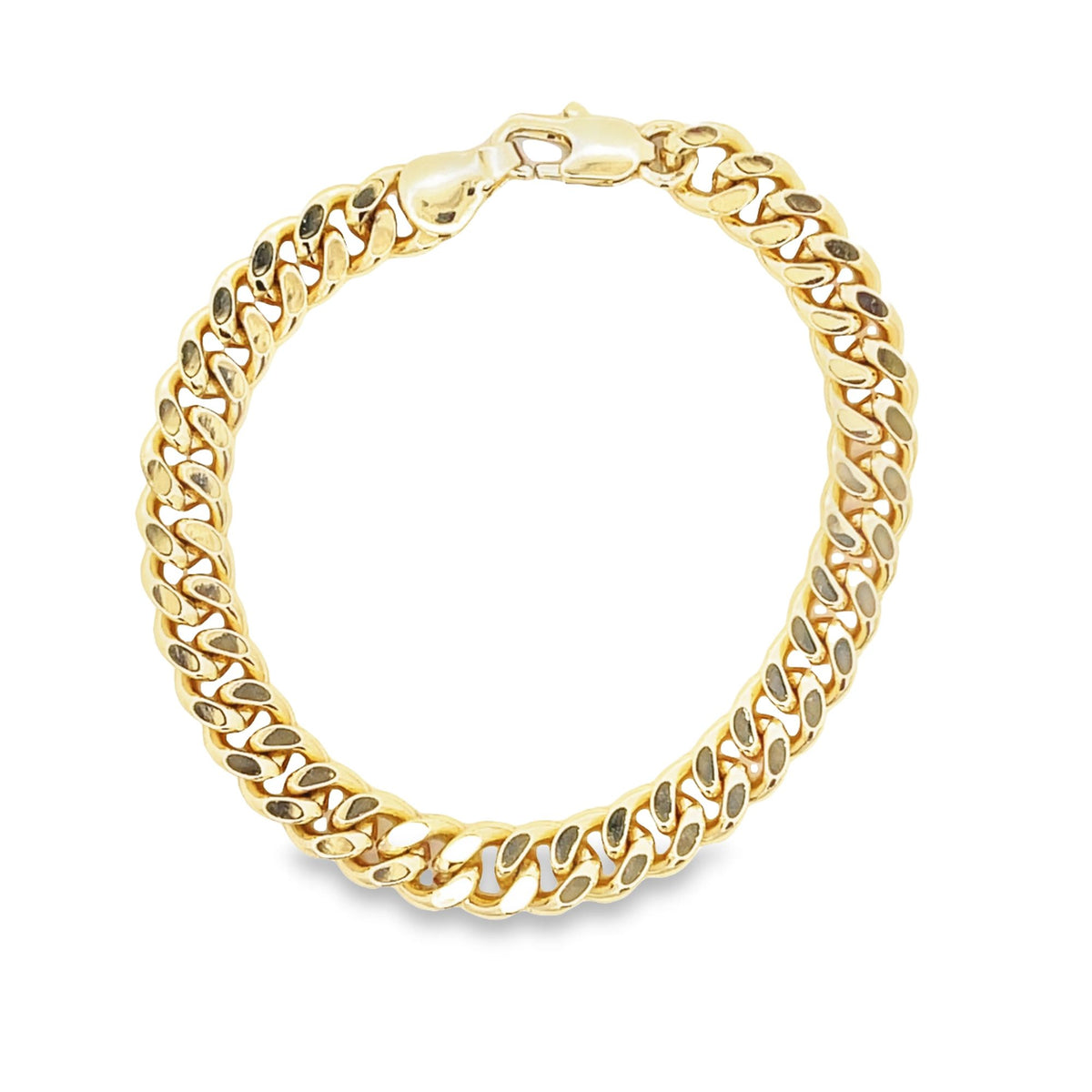 A polished gold curb link bracelet rests on a white background, displaying its classic interlocking design.