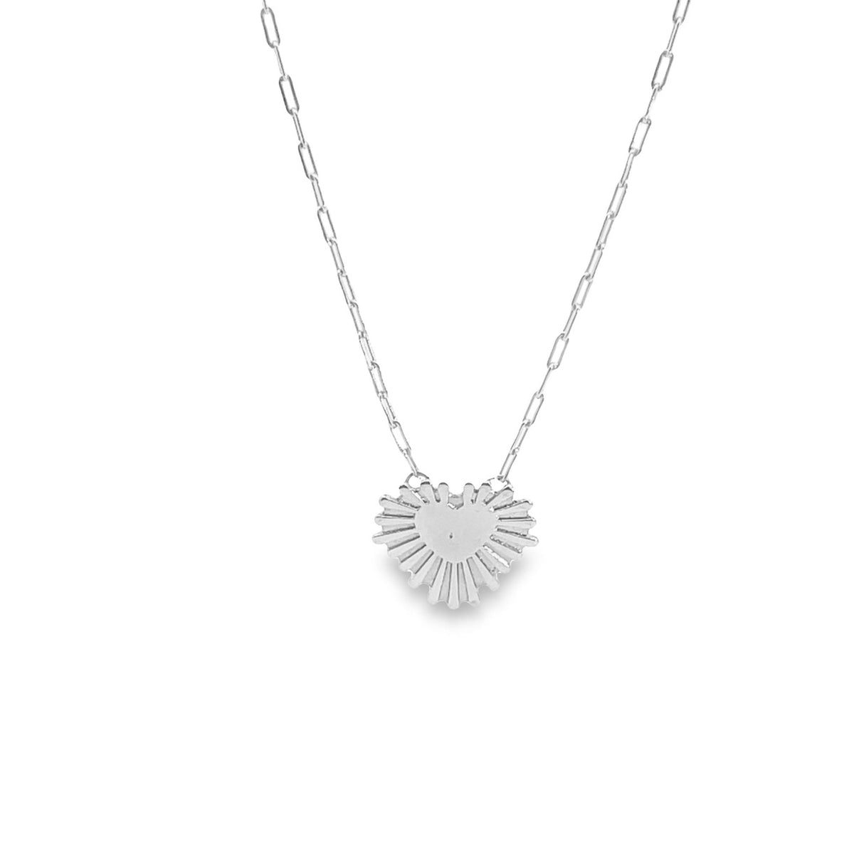 A delicate silver chain necklace features a unique heart-shaped pendant with radiating sunburst rays.