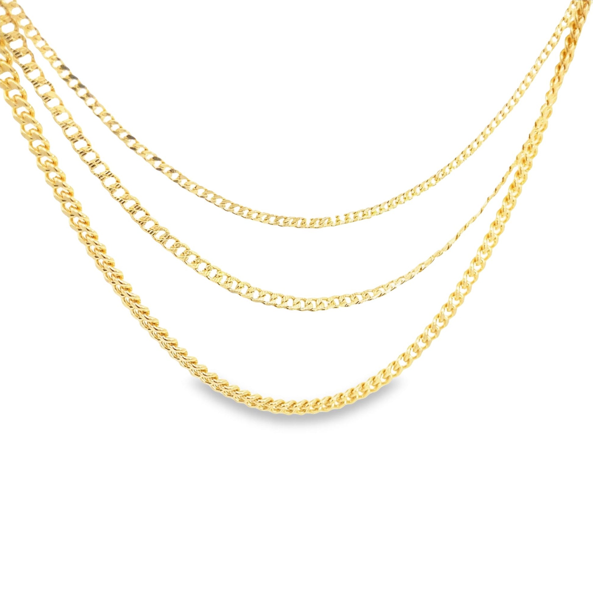 Three layered gold chains in different link styles drape gracefully against a plain white background.