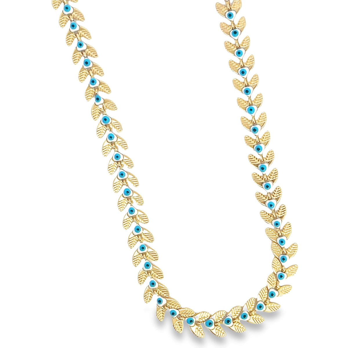 A gold leaf necklace adorned with turquoise and white evil eye beads hangs against a white background.