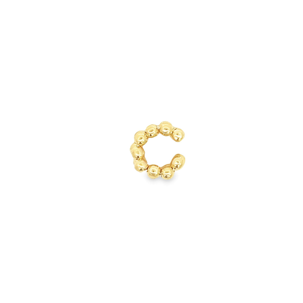A polished gold beaded ear cuff rests against a clean white background.