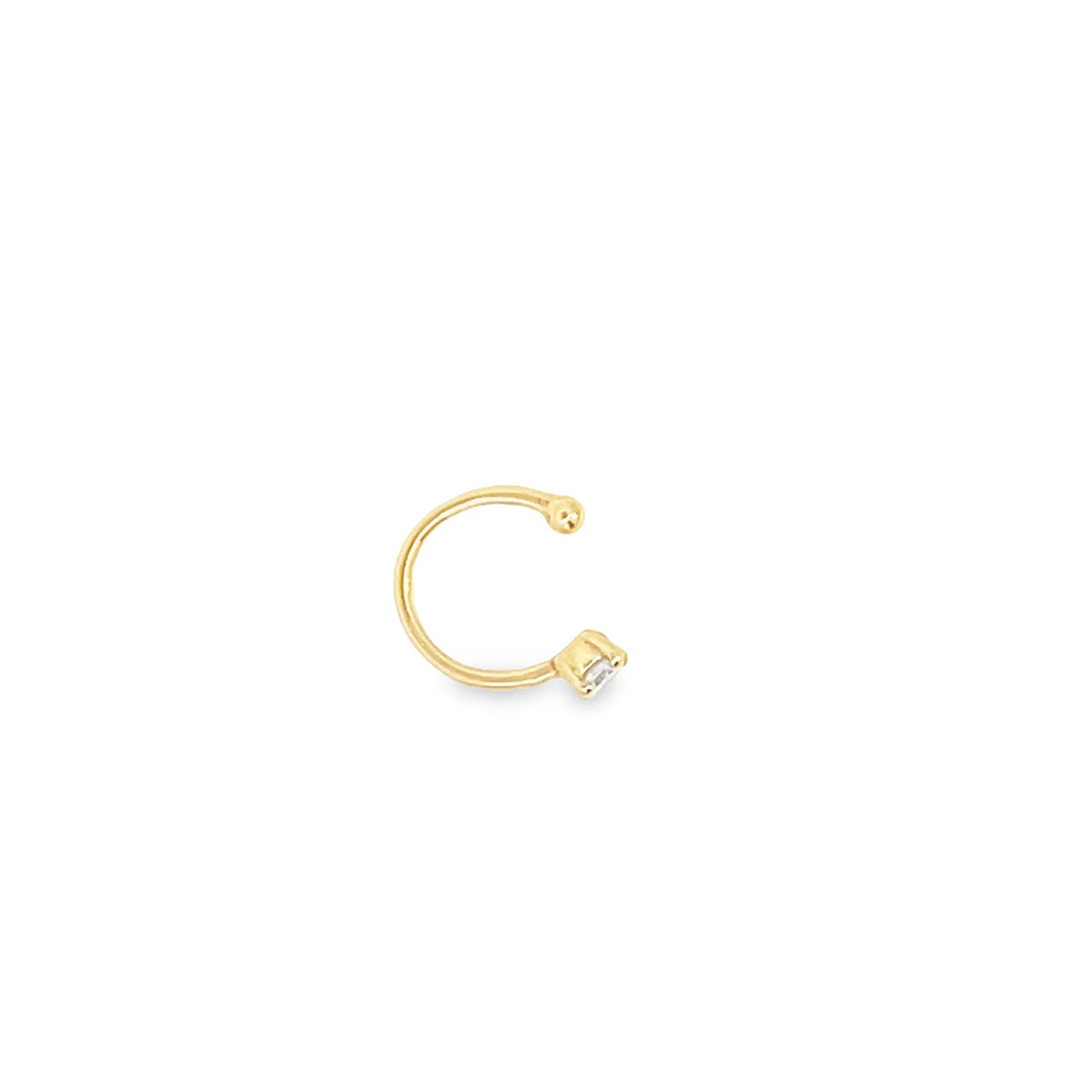 A delicate gold hoop nose ring features a sparkling diamond accent on a white background.