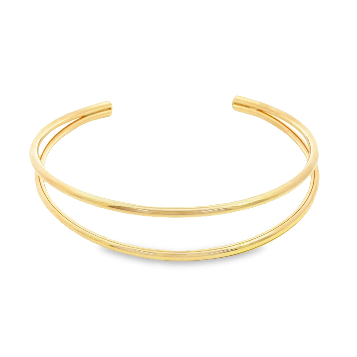 A sleek double-band gold cuff bracelet rests against a clean white background.