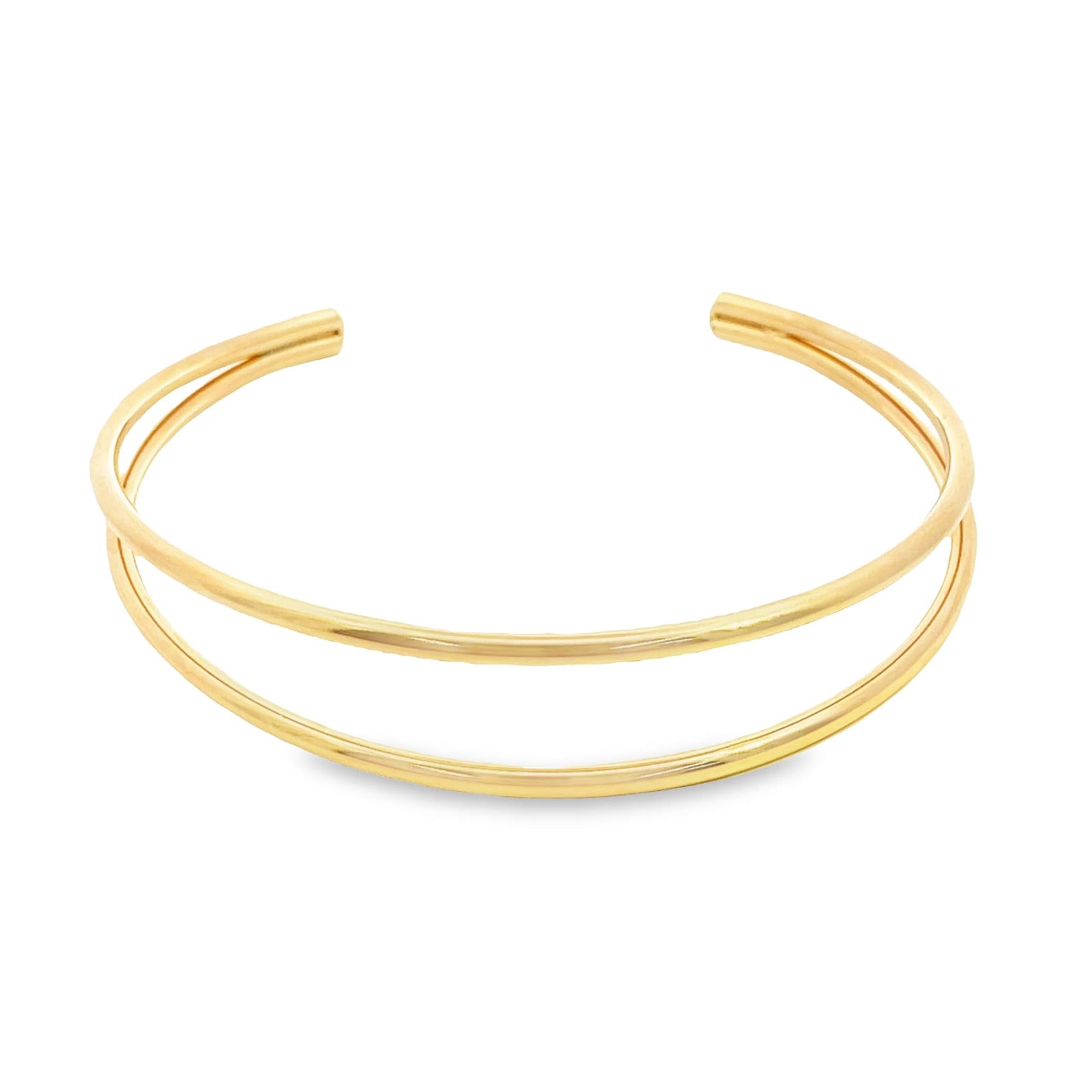 A sleek double-band gold cuff bracelet rests against a clean white background.