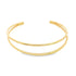A sleek double-band gold cuff bracelet rests against a clean white background.