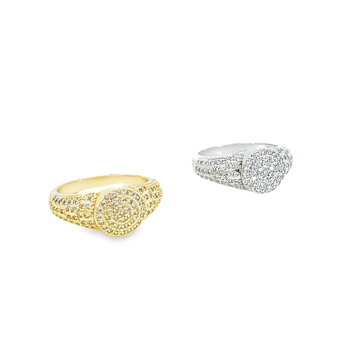 A gold and silver pave diamond signet ring pair rests against a white background.