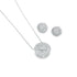 A sparkling silver diamond pendant necklace rests beside matching round cluster stud earrings on a clean white background.