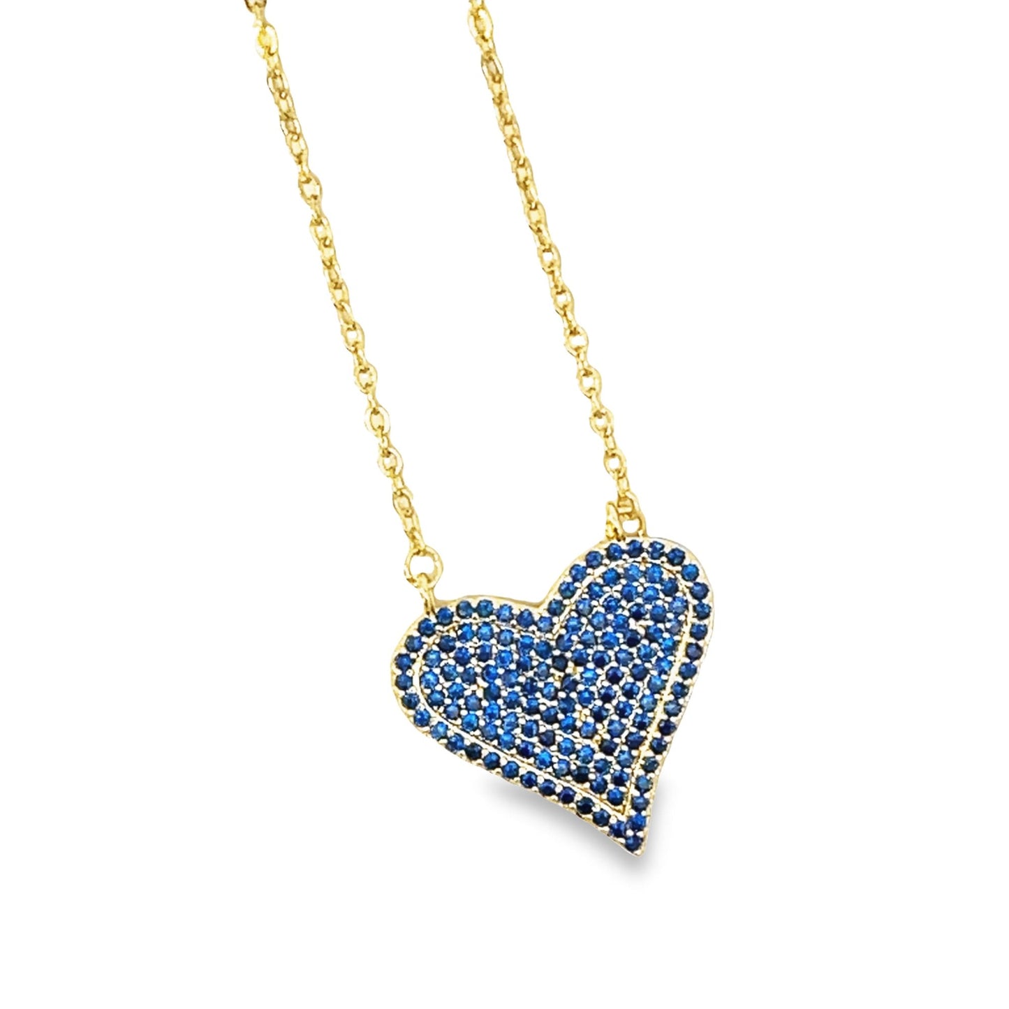 A delicate gold chain holds a paved blue sapphire heart pendant against a white background.