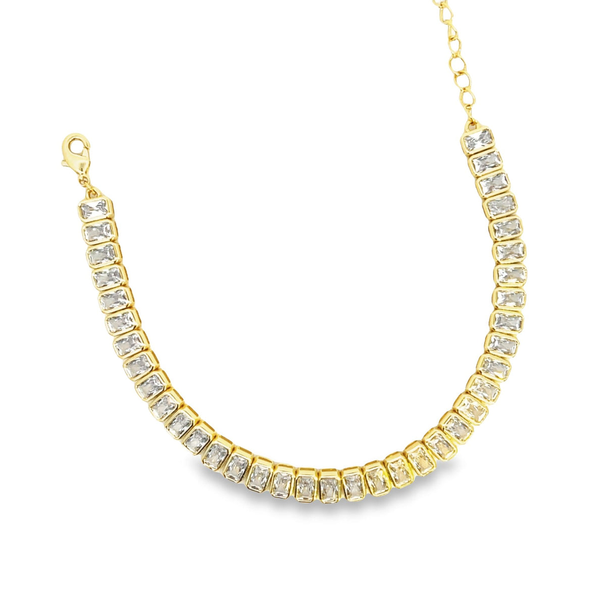 A gold tennis bracelet sparkles with a continuous line of rectangular-cut cubic zirconia stones against a white background.