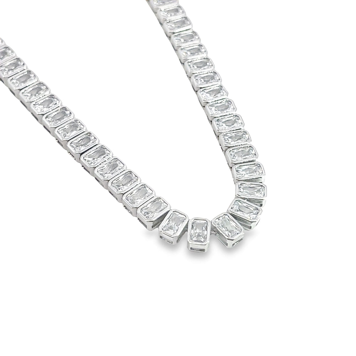 A sparkling silver tennis necklace features a continuous line of brilliant emerald-cut cubic zirconia stones.