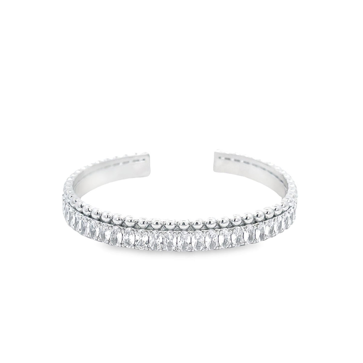 A silver cuff bracelet features a row of sparkling baguette-cut diamonds bordered by delicate beading against a clean white background.