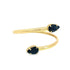 A bypass gold ring features two opposing pear-cut dark sapphires in prong settings against a plain white background.