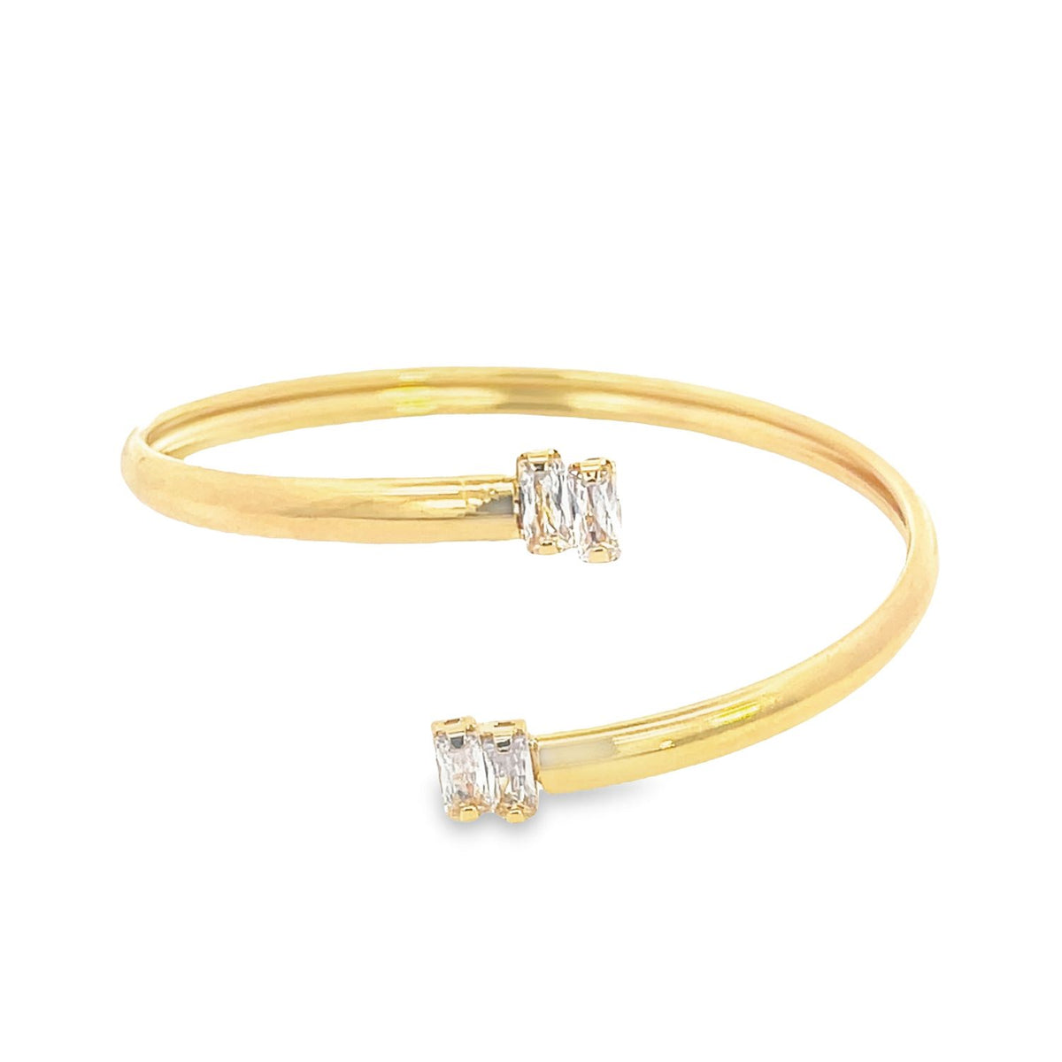 A sleek gold cuff bracelet sparkles with baguette-cut diamonds on its open ends.