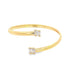 A sleek gold cuff bracelet sparkles with baguette-cut diamonds on its open ends.
