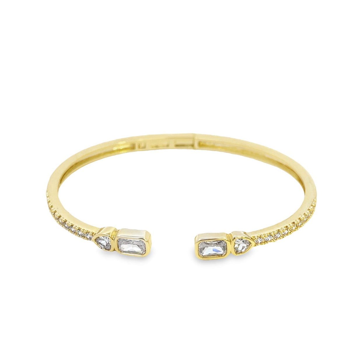 A sleek gold cuff bracelet sparkles with baguette and round CZ stones against a clean white background.